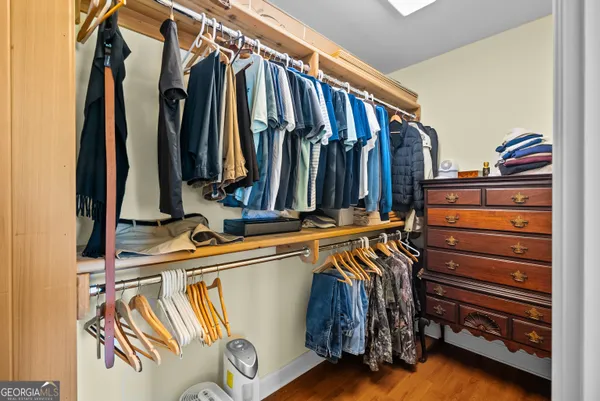 a view of walk in closet with clothes and shoes