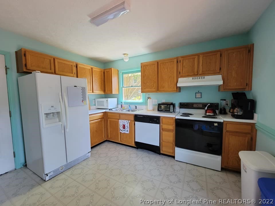 5025 Summer Ridge Road Fayetteville, NC 28303 - Photo 2 of 9 a kitchen with granite countertop a refrigerator a sink dishwasher stove and oven with cabinets