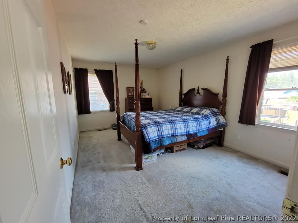 5025 Summer Ridge Road Fayetteville, NC 28303 - Photo 4 of 9 a bedroom with a bed window and mirror