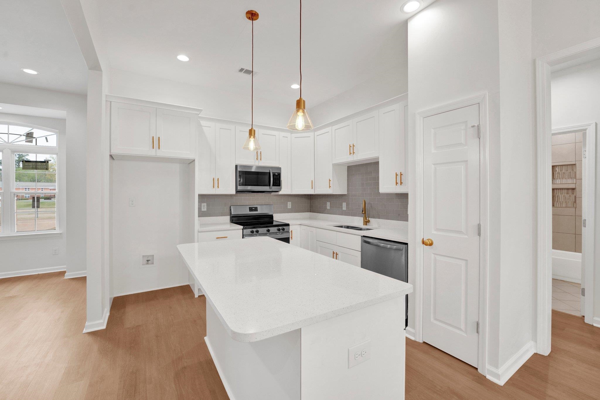 4056 Fonta Road Bartlett, TN 38002 - Photo 11 of 39 Kitchen featuring a sink, white cabinetry, tasteful backsplash, appliances with stainless steel finishes, and light wood-style flooring