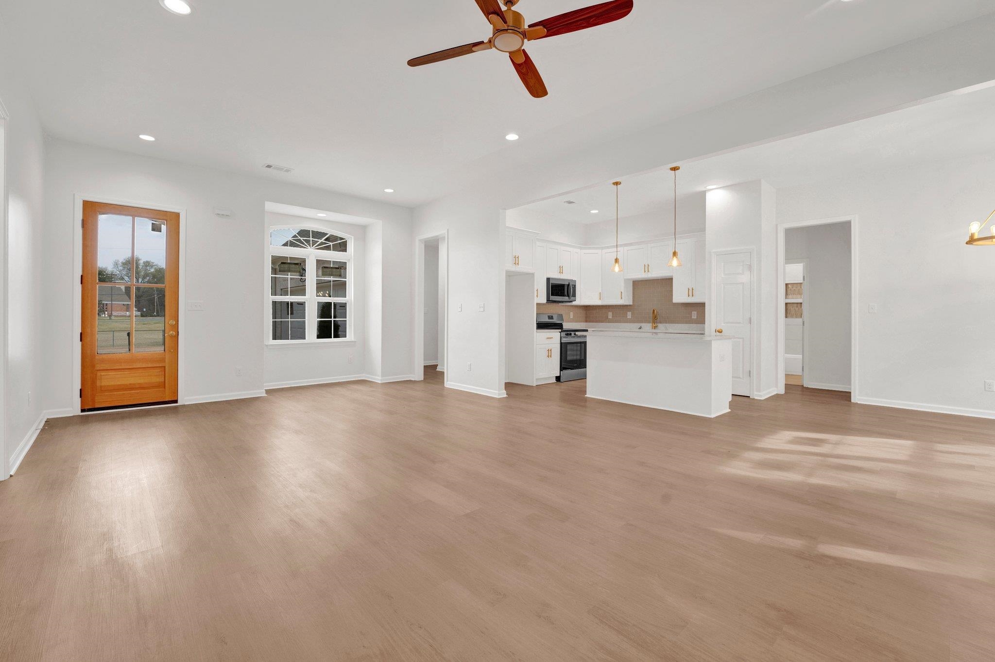 4056 Fonta Road Bartlett, TN 38002 - Photo 6 of 39 Unfurnished living room featuring light wood finished floors, ceiling fan with notable chandelier, baseboards, and recessed lighting