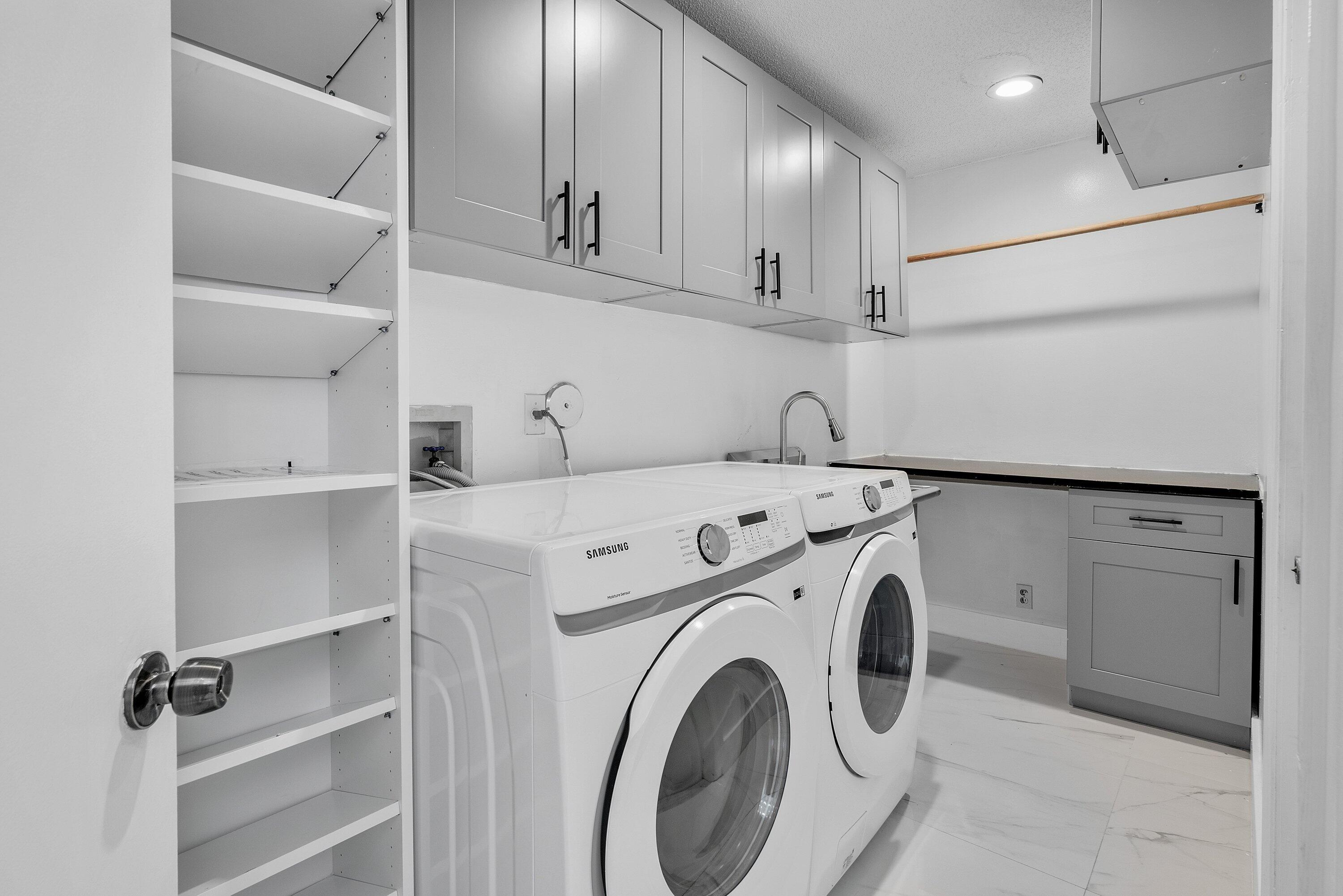 11163 180th Court South Boca Raton, FL 33498 - Photo 15 of 22 a view of washer and dryer with wooden cabinets