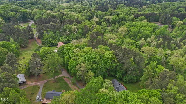 an aerial view of residential houses with outdoor space and trees