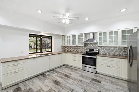 a kitchen with stainless steel appliances kitchen island granite countertop a refrigerator and a stove top oven