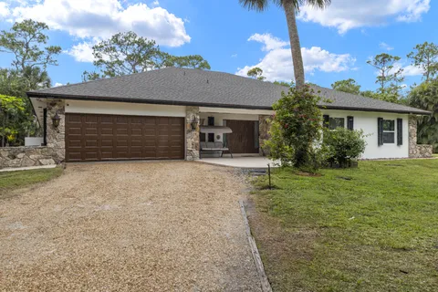 front view of a house with a yard and garage