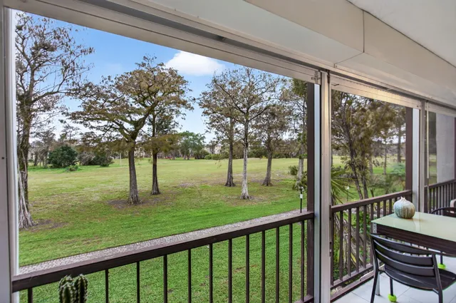 a view of a deck and a backyard with a garden