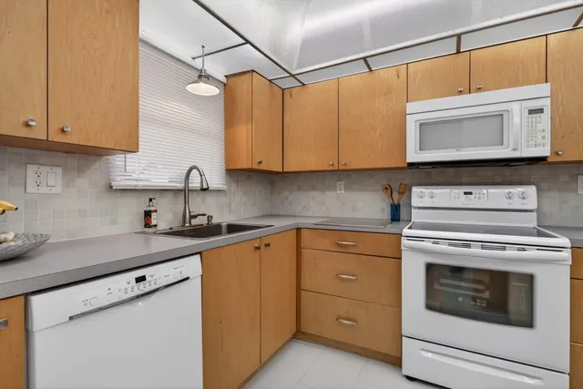 a kitchen with cabinets stainless steel appliances and a sink
