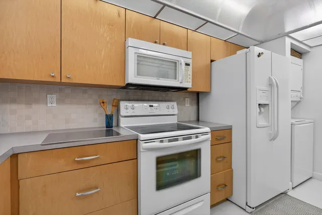 a kitchen with stainless steel appliances white cabinets and a stove top oven
