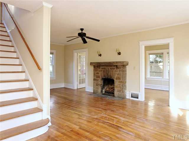 1413 Scales Street Raleigh, NC 27608 - Photo 4 of 24 a view of an empty room with wooden floor fireplace and a window