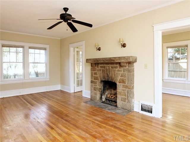 1413 Scales Street Raleigh, NC 27608 - Photo 5 of 24 a view of an empty room with wooden floor fireplace and a window
