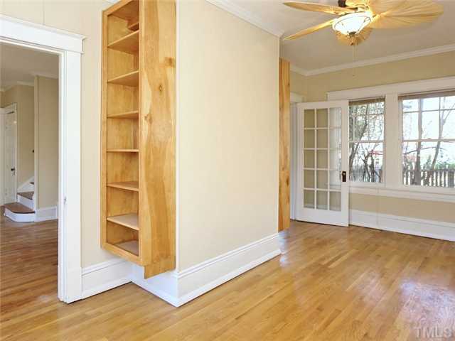 1413 Scales Street Raleigh, NC 27608 - Photo 9 of 24 a view of an empty room with wooden floor and a window