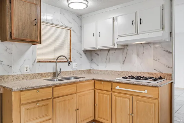 a kitchen with granite countertop a sink stove and cabinets