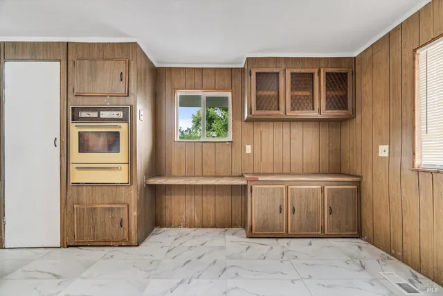 a view of a kitchen with white cabinets and entryway