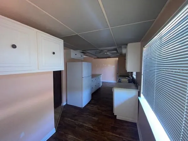 a kitchen with cabinets and wooden floor