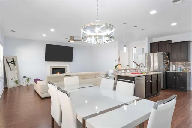 a view of a dining room with furniture a kitchen and chandelier