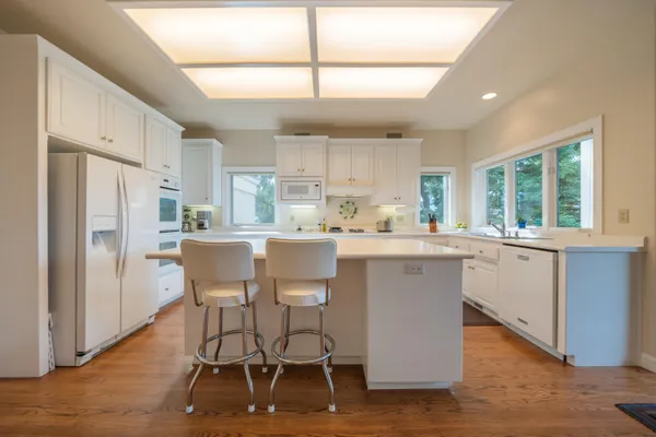 a kitchen with a table chairs refrigerator a sink and cabinets