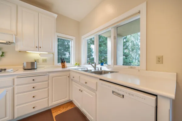 a kitchen with white cabinets and a window