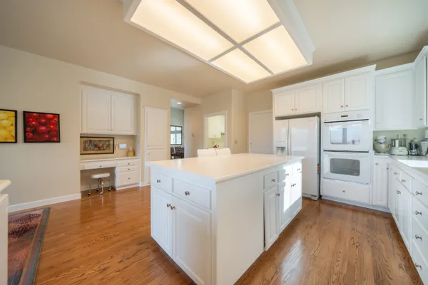 a kitchen with cabinets and wooden floor
