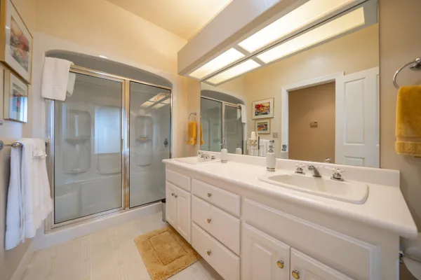 a spacious bathroom with a double vanity sink mirror and shower