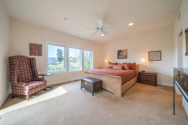 a spacious bedroom with a bed couch and window