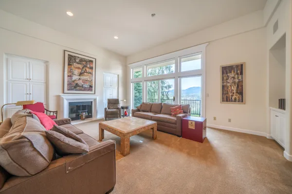 a living room with fireplace furniture and a large window