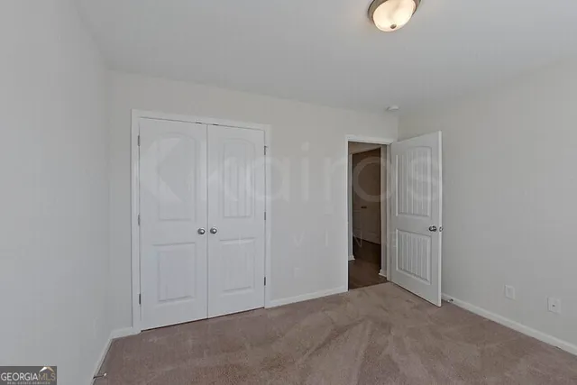 a view of an empty room with closet area