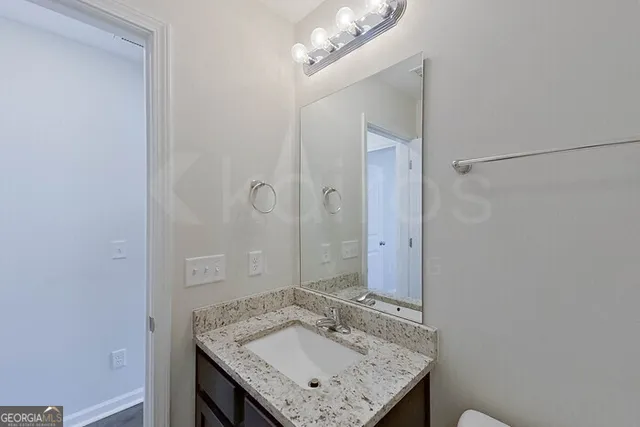 a bathroom with a granite countertop sink a mirror and shower