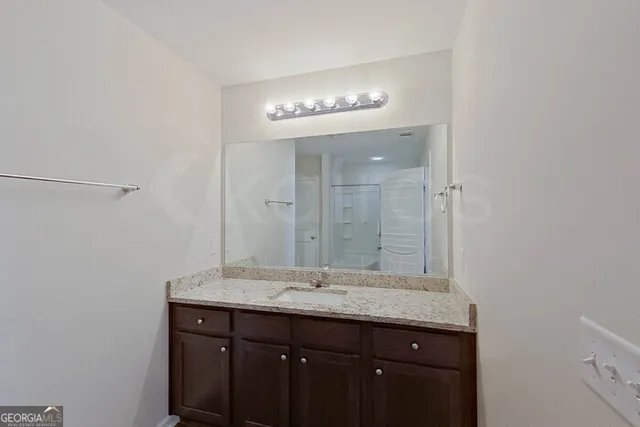 a bathroom with a granite countertop sink two mirror and a