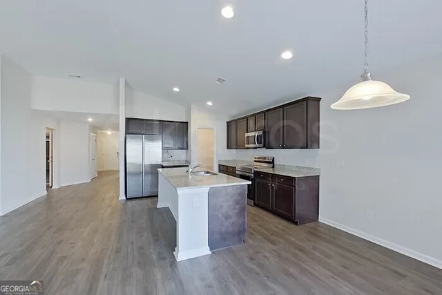a kitchen with stainless steel appliances kitchen island wooden cabinets and granite counter tops