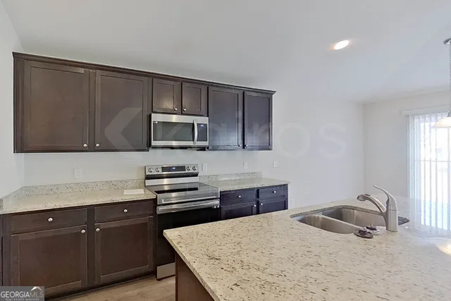 a kitchen with a sink a stove and microwave