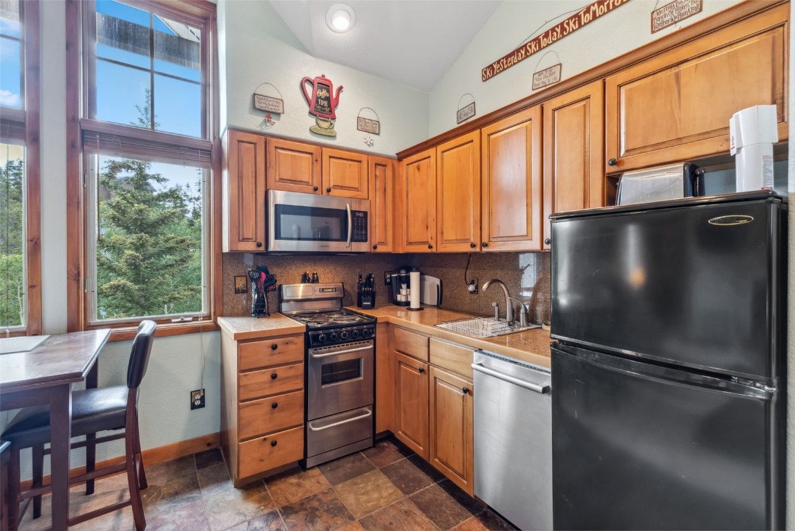 655 4 O Clock Road, Unit 301 Breckenridge, CO 80424 - Photo 10 of 23 a kitchen with stainless steel appliances granite countertop a refrigerator stove and a sink with large windows