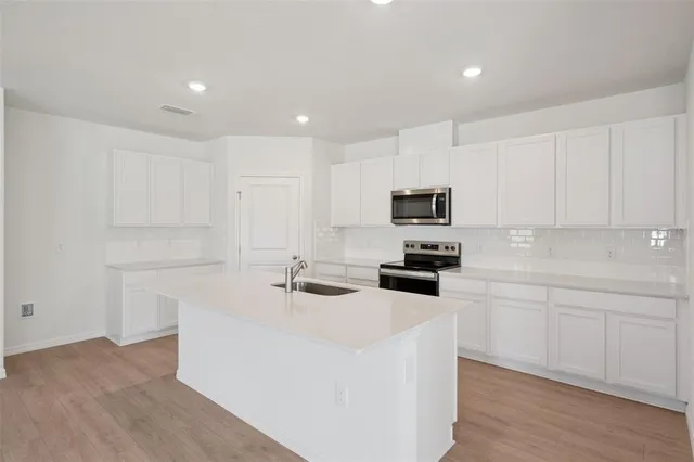 a kitchen with sink cabinets and microwave