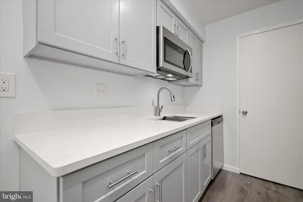 a kitchen with stainless steel appliances granite countertop a sink refrigerator and microwave