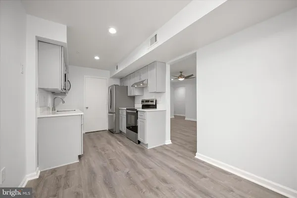wooden floor in an empty room with a chandelier fan