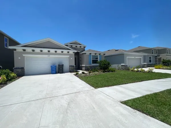 a front view of a house with a yard and garage