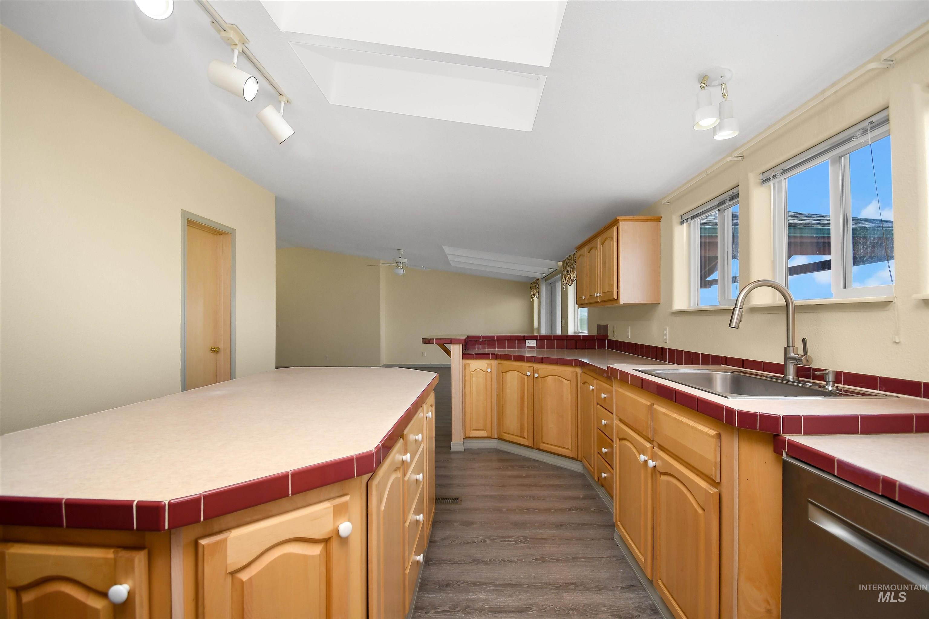 11375 Timber Butte Road Sweet, ID 83670 - Photo 15 of 49 Expansive kitchen featuring light wood cabinetry, tiled countertops with red accent trim, a stainless steel sink with gooseneck faucet, and a stainless steel dishwasher