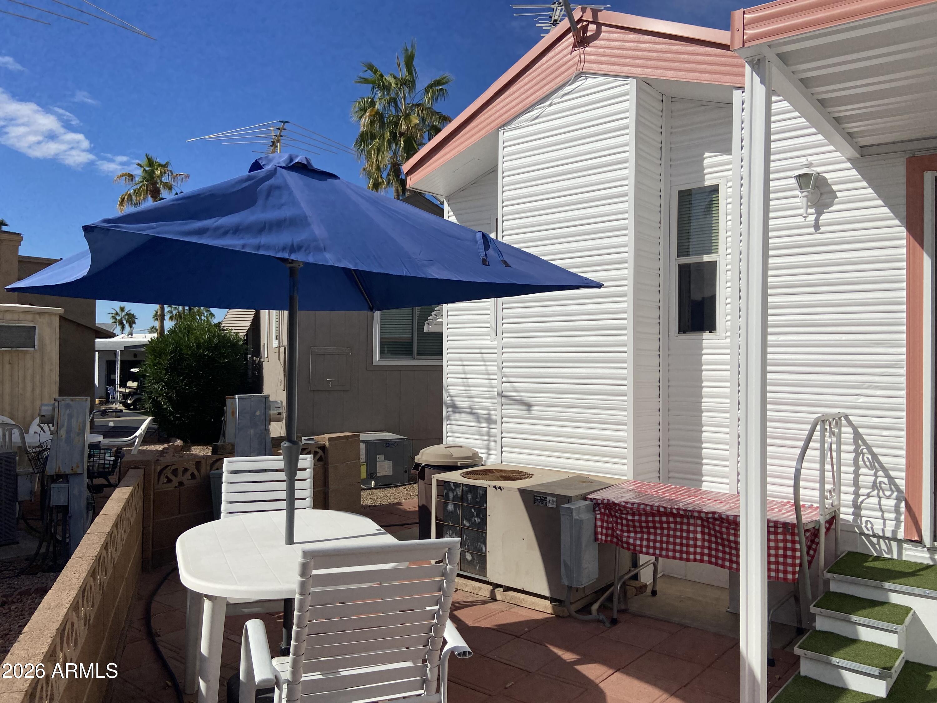 1336 West Inuit Avenue, Unit 336 Apache Junction, AZ 85119 - Photo 25 of 35 a view of a patio with a table and chairs under an umbrella