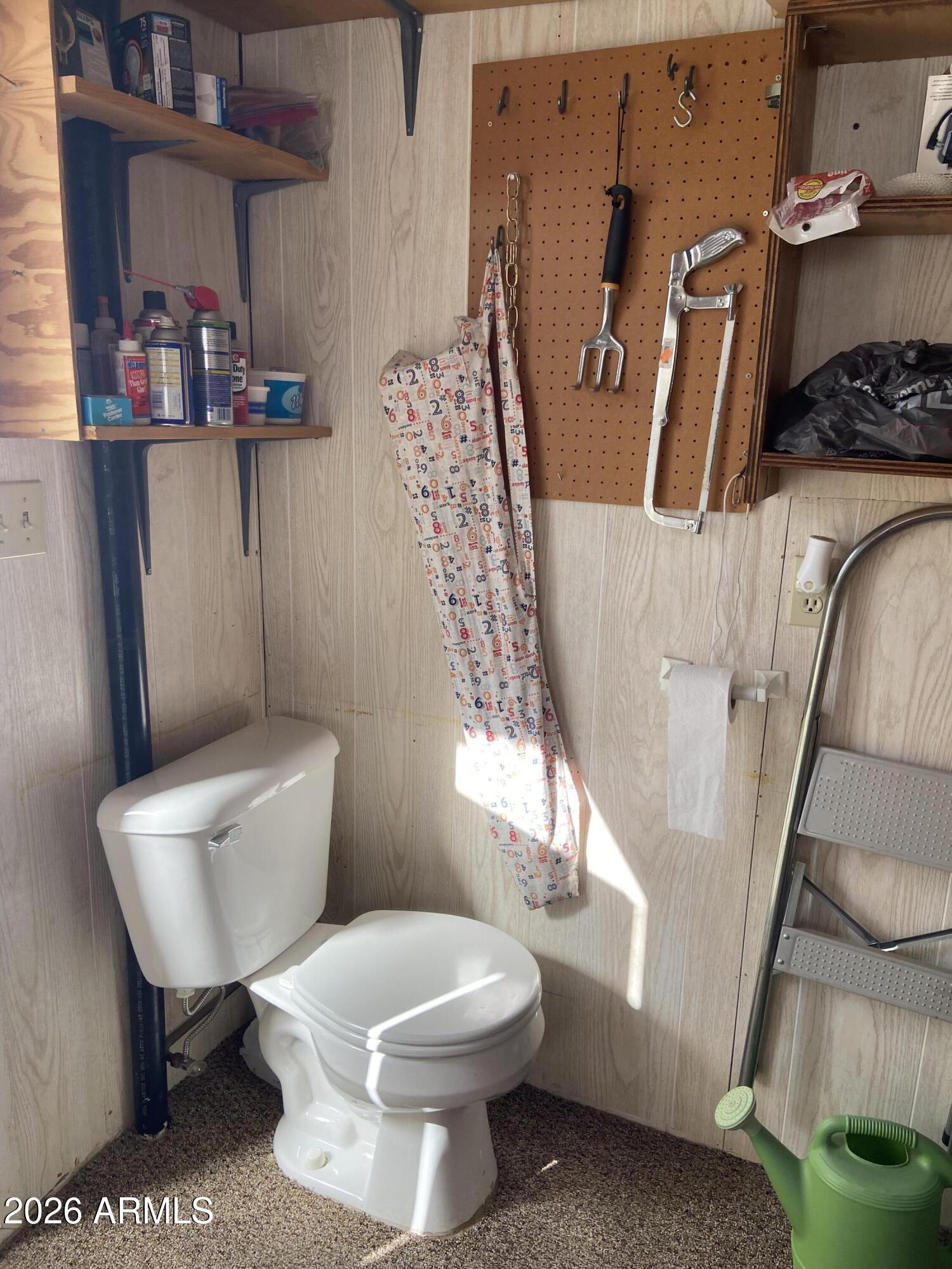 1336 West Inuit Avenue, Unit 336 Apache Junction, AZ 85119 - Photo 29 of 35 a white toilet sitting next to a bathroom sink and a mirror