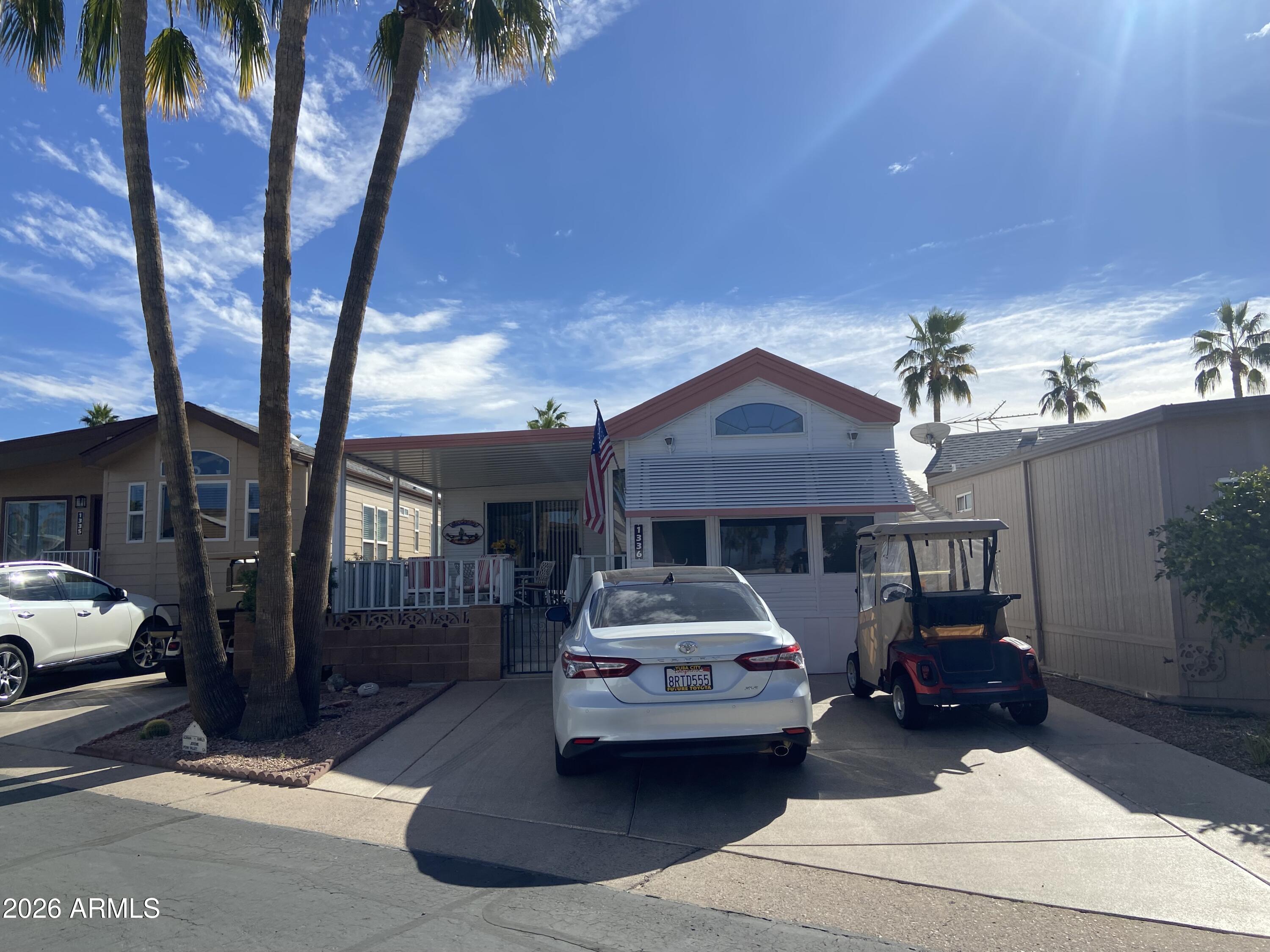 1336 West Inuit Avenue, Unit 336 Apache Junction, AZ 85119 - Photo 35 of 35 a car parked in front of a houses