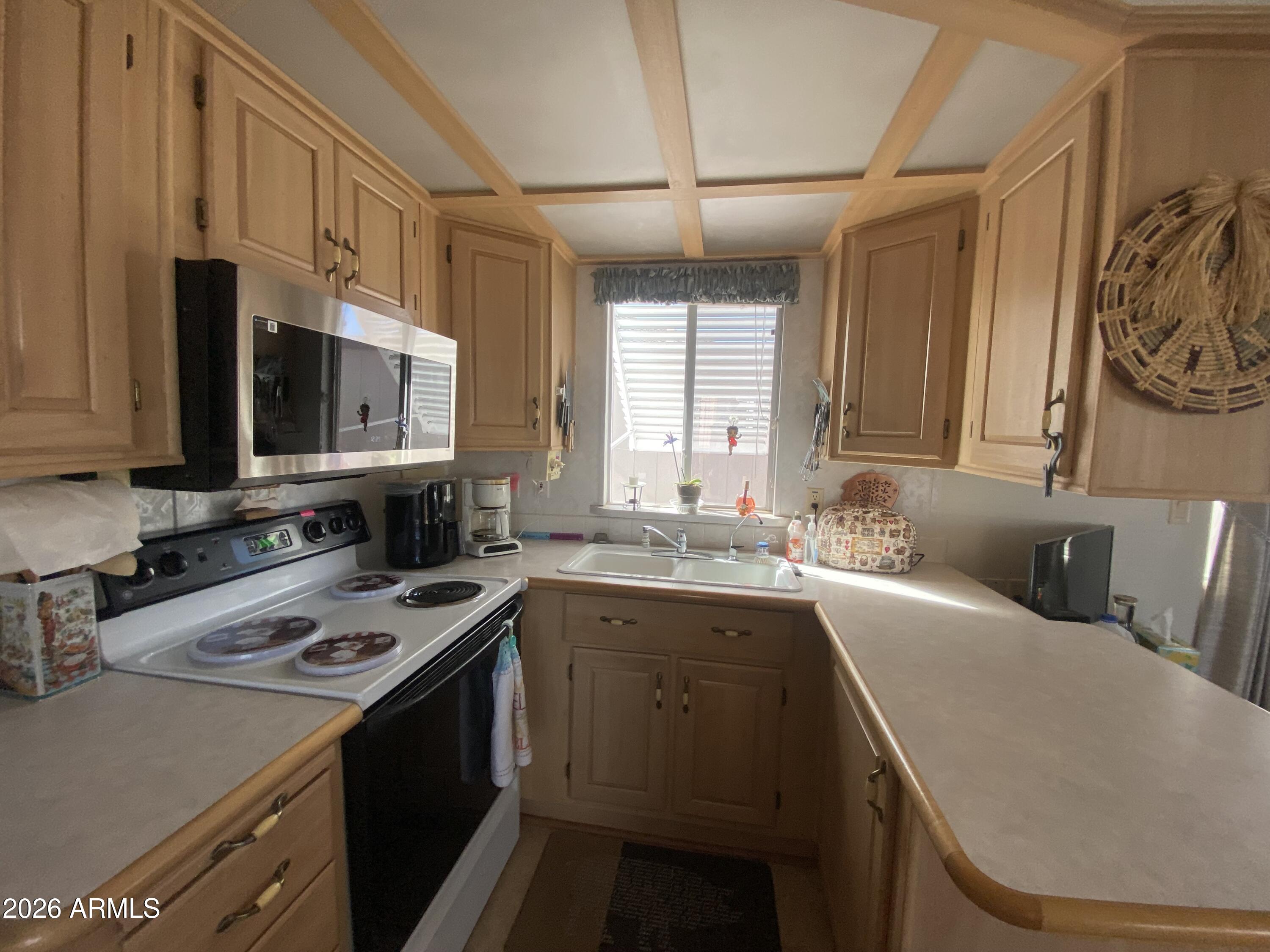 1336 West Inuit Avenue, Unit 336 Apache Junction, AZ 85119 - Photo 10 of 35 a kitchen with a sink a stove and cabinets