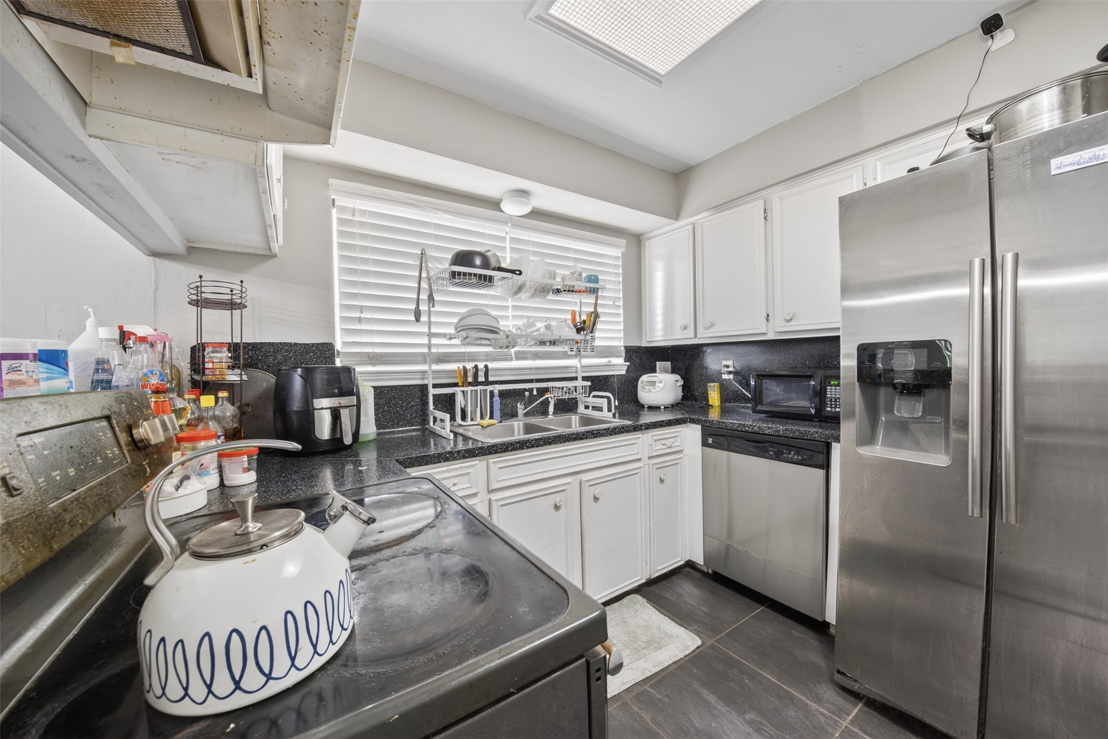 8029 Tareyton Lane Houston, TX 77075 - Photo 7 of 20 a kitchen with stainless steel appliances granite countertop a sink a stove a chimney a refrigerator and cabinets