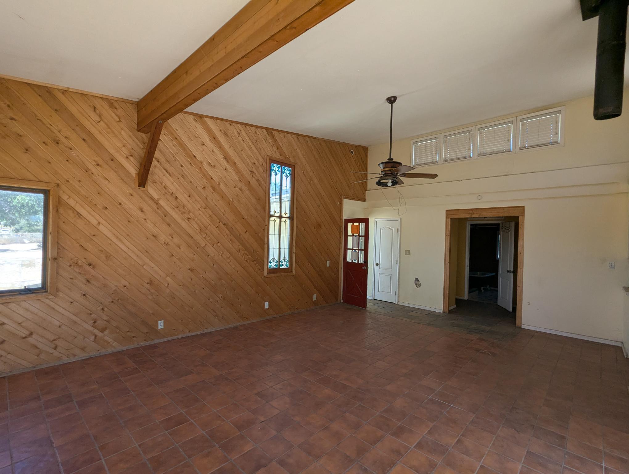 58841 Granite Gulley Road Anza, CA 92539 - Photo 6 of 18 an empty room with a chandelier fan and windows
