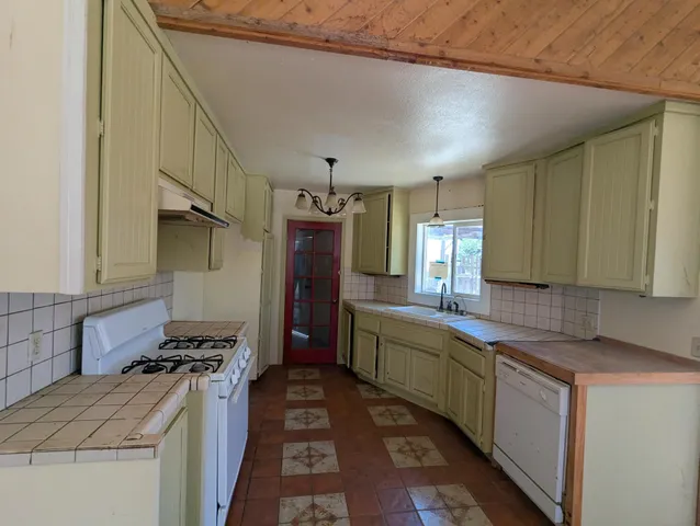 a kitchen that has a sink and a stove in it