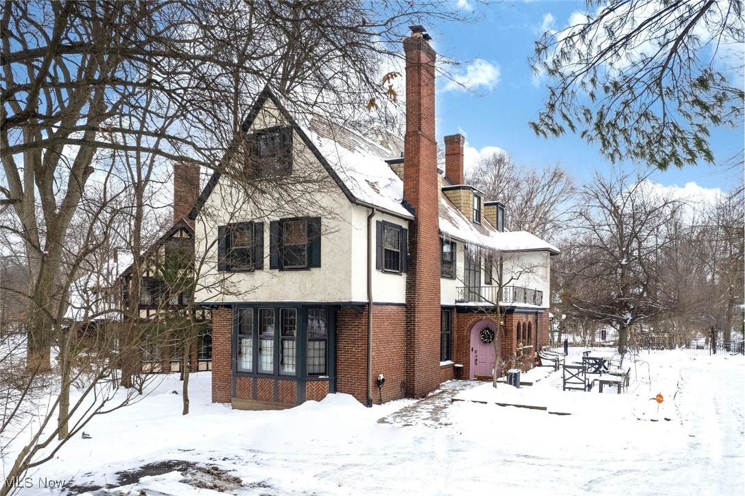 Front exterior of tudor and brick home in the snow.