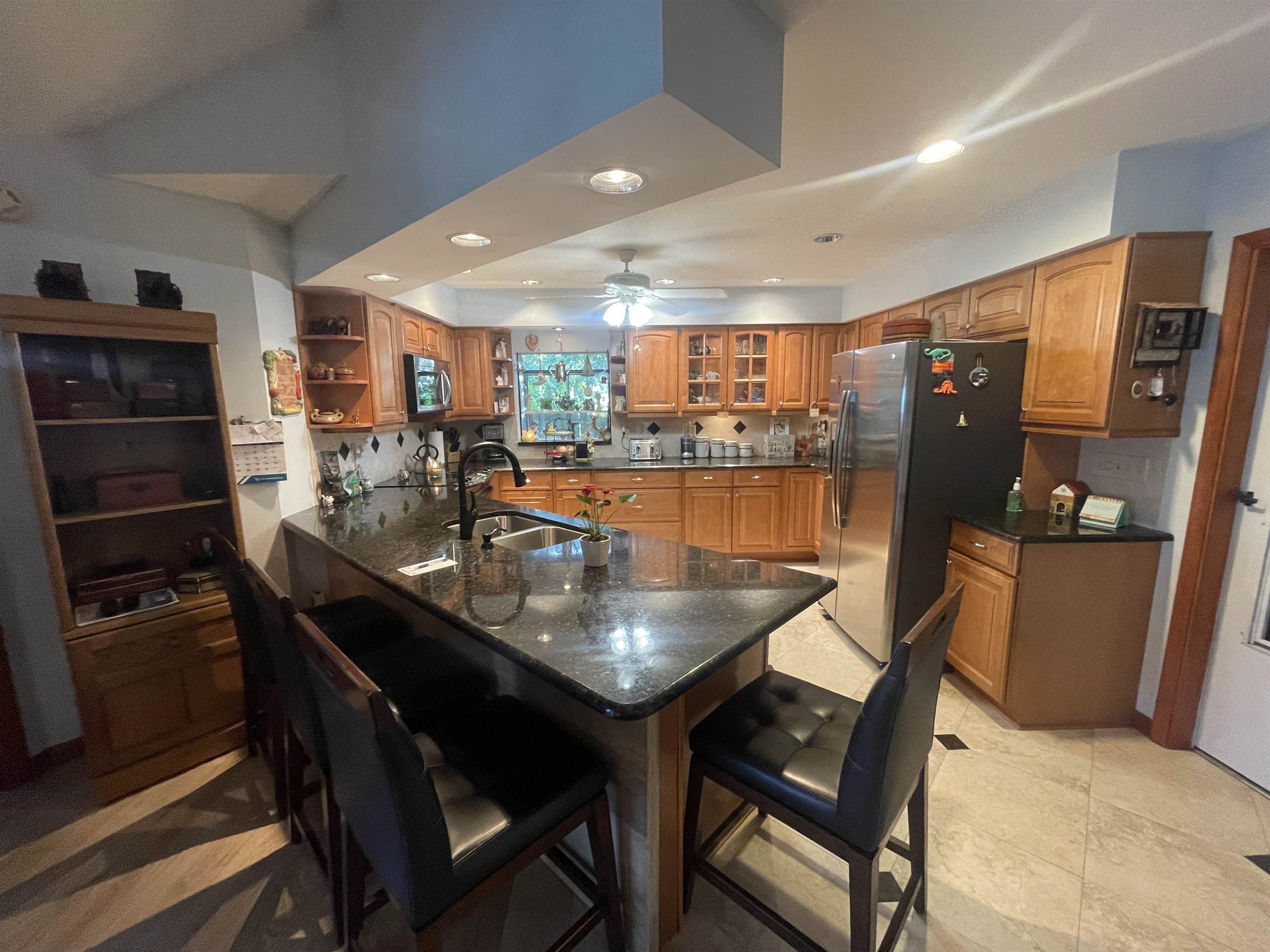 6325 Salado Road St. Augustine, FL 32080 - Photo 14 of 28 a dining hall with stainless steel appliances a dining table and chairs with wooden floor
