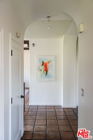 a kitchen with white cabinets and window