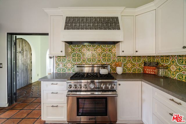 a kitchen with stainless steel appliances granite countertop a refrigerator and a stove