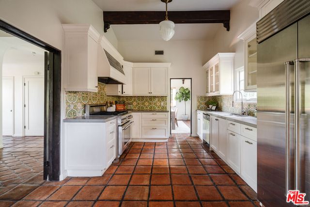 a kitchen with stainless steel appliances granite countertop a sink a stove and a window