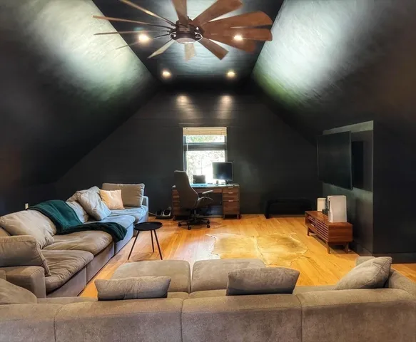 a living room with furniture and a ceiling fan