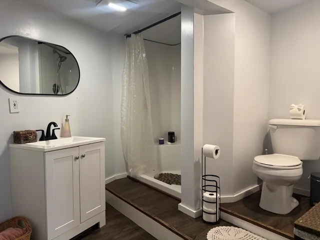 a bathroom with a toilet sink and mirror